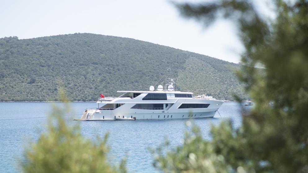 Even from a distance, the luxury yacht shines in its full glory in front of a bay in Fetiye.
